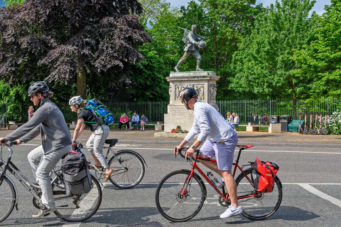 Cyclists ride by Hills Rd war memorial